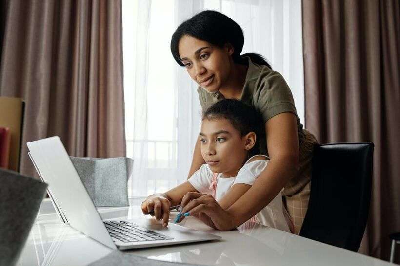 A mother and her young daughter using a computer