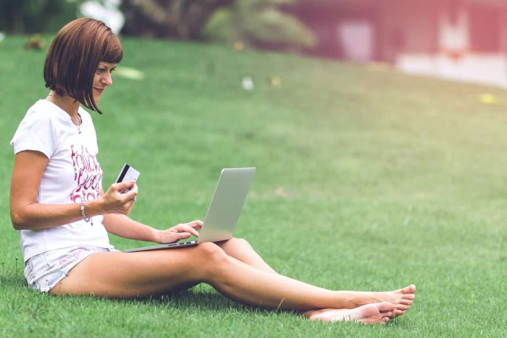 Woman sitting in lawn ordering online